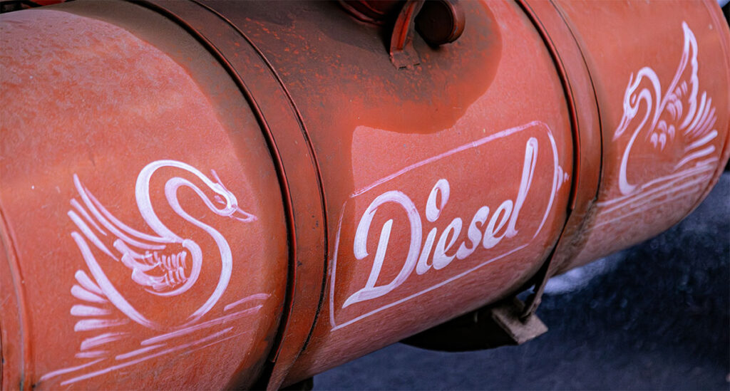 Red diesel barrel painted with decorative white swans