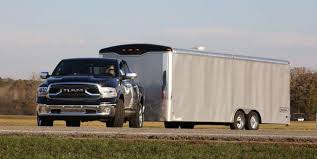 Black pickup truck towing large silver trailer