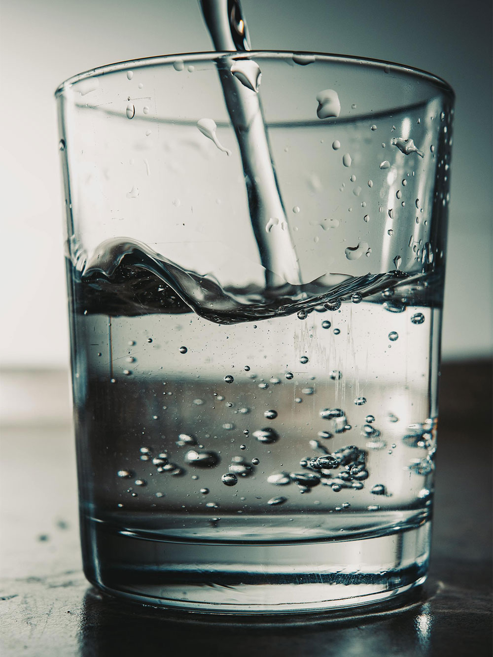 Clear diesel pouring into glass with bubbles