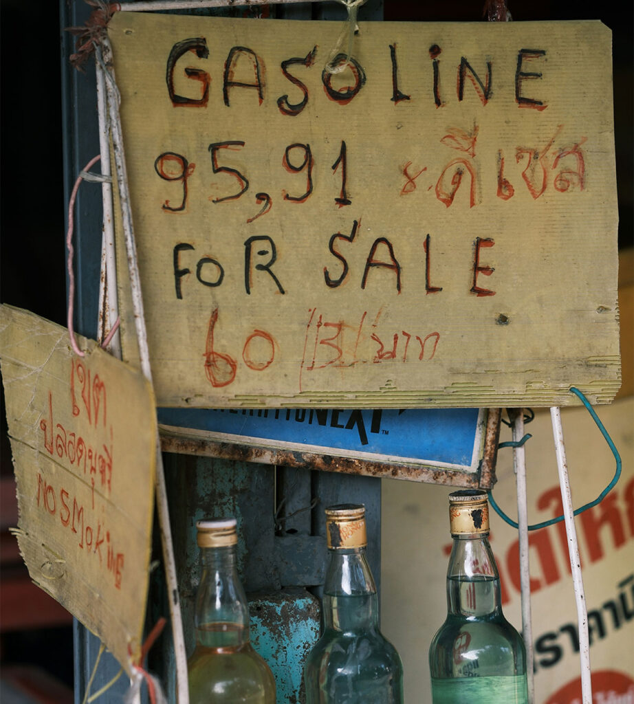 Handwritten gasoline for sale sign with bottles