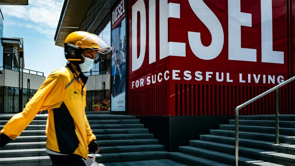 Man in yellow jacket walking past Diesel
