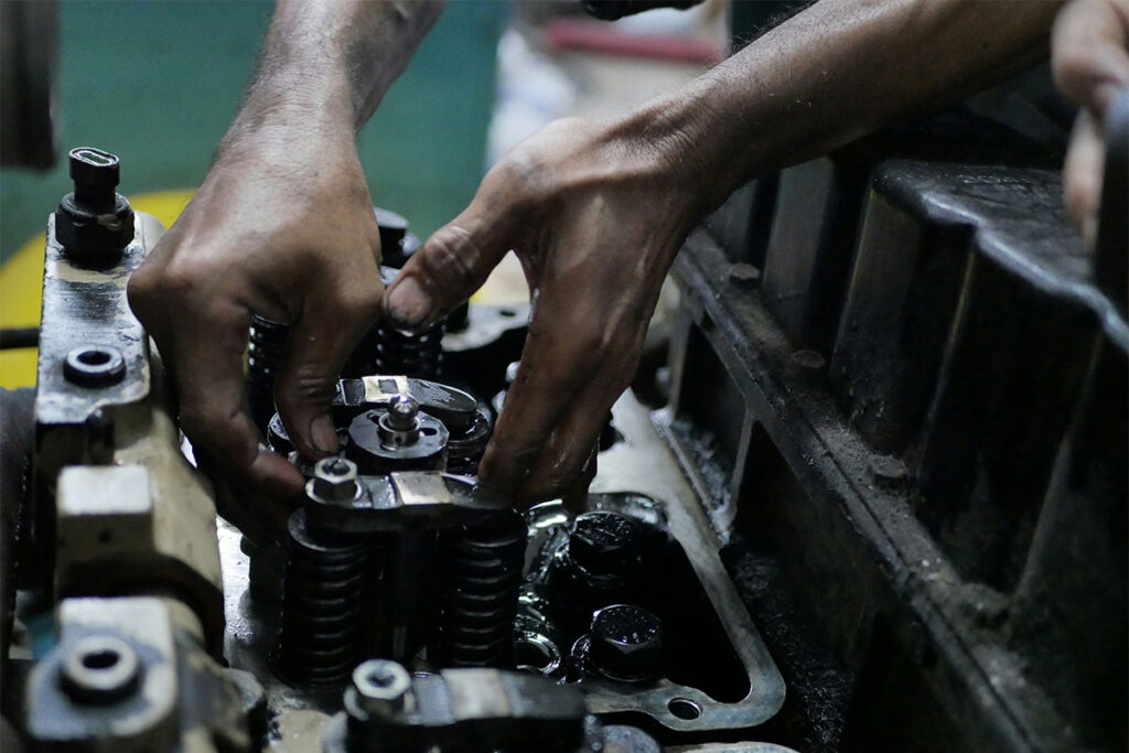 Mechanic repairing engine components with greasy hands