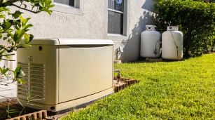 Residential standby generator near propane gas tanks