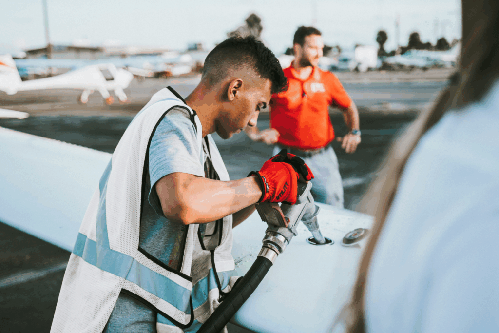 Man filling wing tank of aircraft