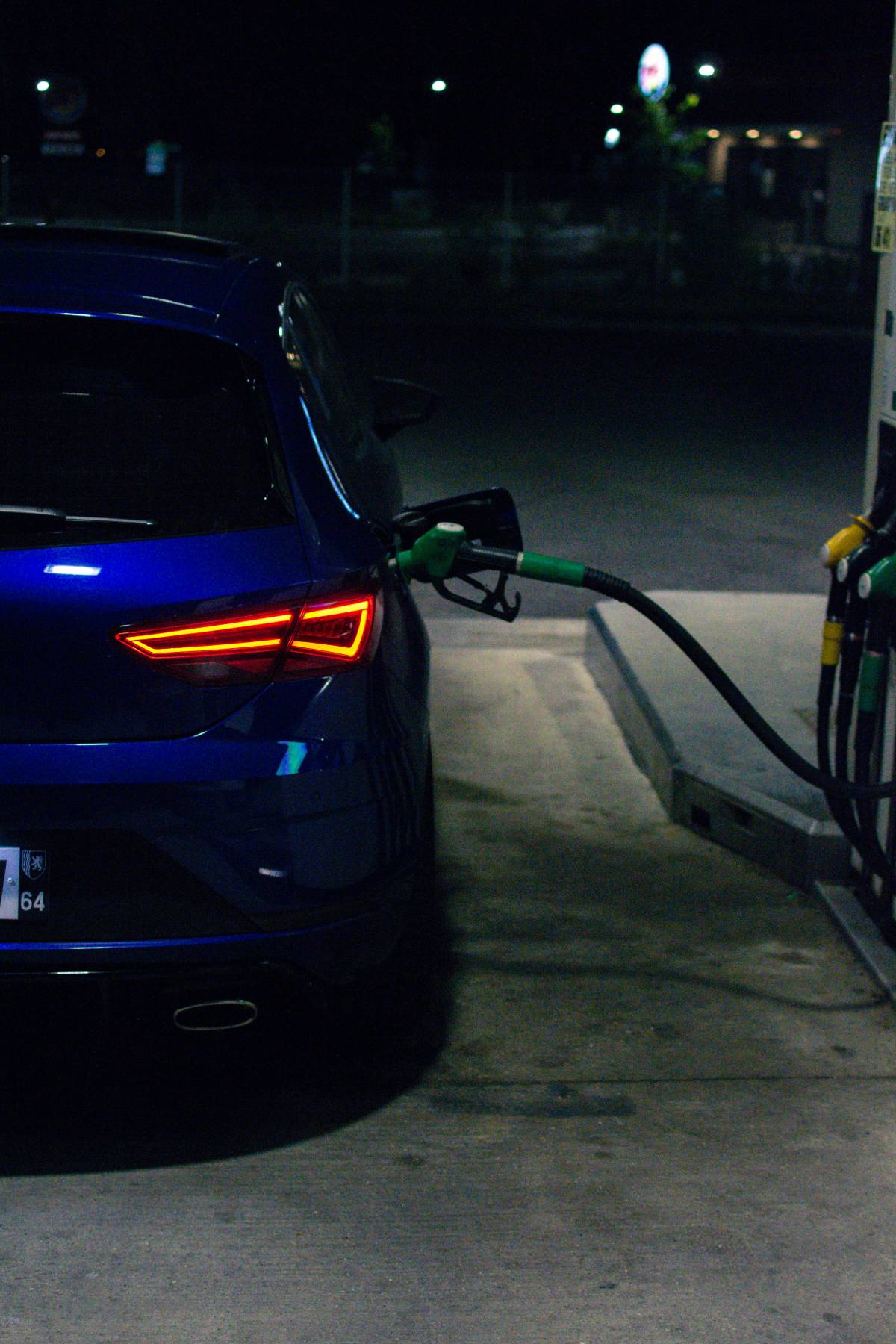 Blue car with fuel dispenser plugged in