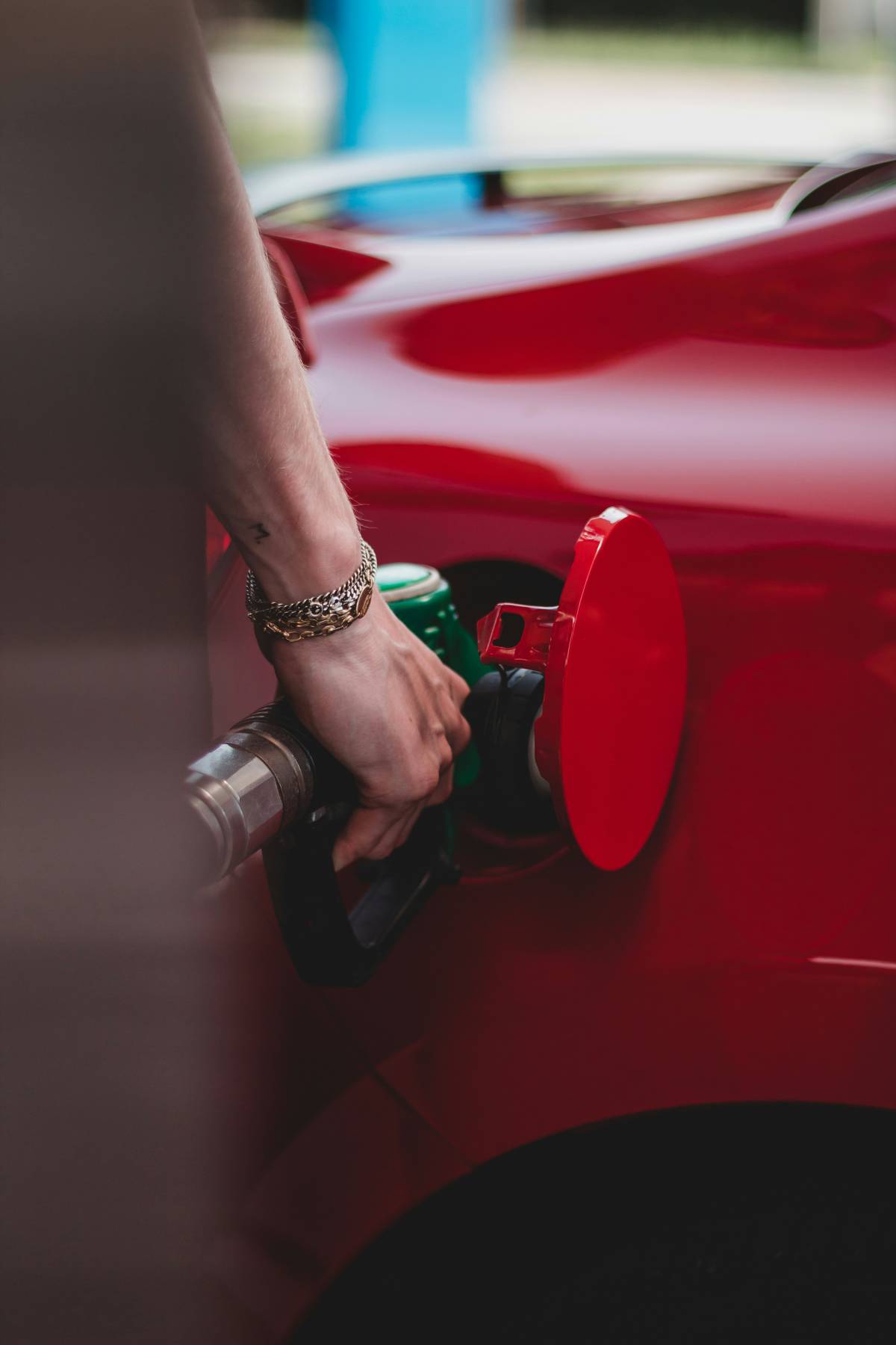 Man pumping fuel into red car