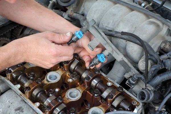 Man handing fuel injectors with bare hands