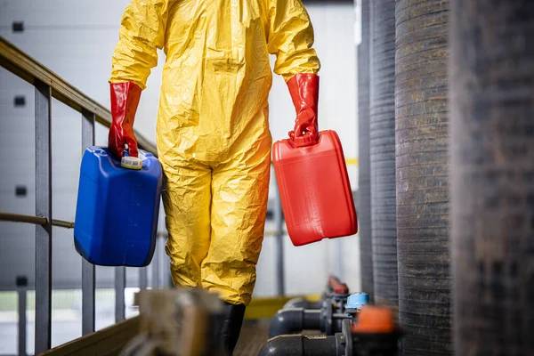 Man in hazmat suit carrying containers
